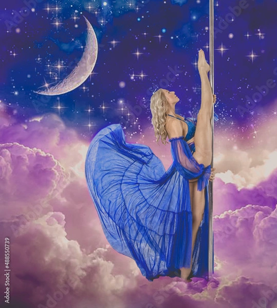 Fototapeta Poledance blonde with a beautiful figure with long legs a dancer in a blue beautiful outfit beautifully and gracefully in leg-split stands beautifully near a pylon in the clouds with a fantasy moon