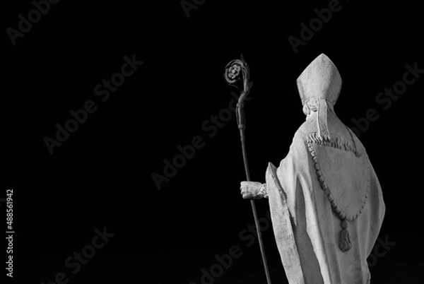 Fototapeta Catholic Church. Bishop with mitre and crosier, an old white marble statue on Lucca old walls, erected in the 17th century (Black and White with copy space)