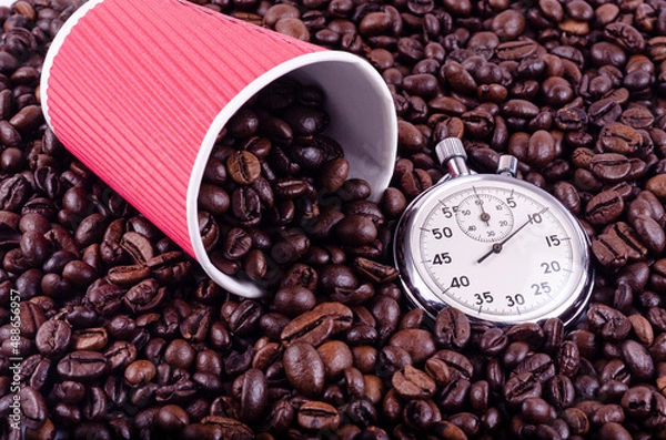 Obraz Red paper cup and stopwatch on a background of coffee beans