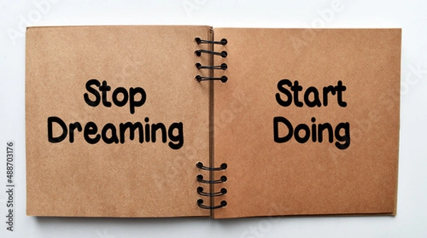 Fototapeta Stop dreaming, start doing, motivating quotation phrase. Inspirational motivating quote on notebook paper.