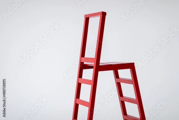 Fototapeta Red wooden staircase on a light background. Ladder. Garden tools. Lifting device. copy space.