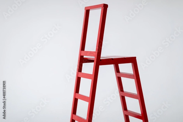 Fototapeta Red wooden staircase on a light background. Ladder. Garden tools. Lifting device. copy space.