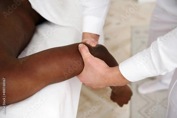 Obraz African american man having massage in spa, white background. Copy space
