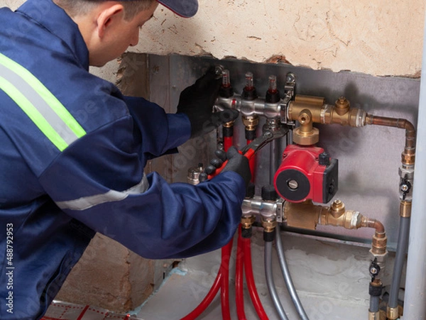 Obraz Technician installing underfloor heating collector