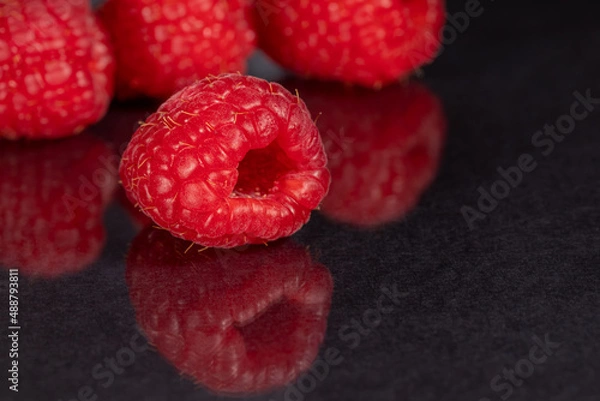 Obraz Raspberries on a black mirror background