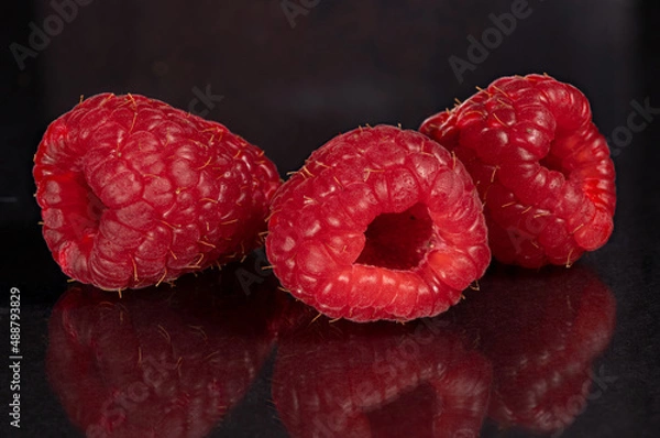 Obraz Raspberries on a black mirror background