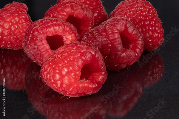 Obraz Raspberries on a black mirror background