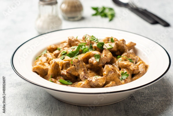 Fototapeta Traditional Russian dish Beef stroganoff in plate on concrete background