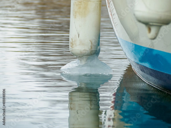 Obraz Icy white fenders suspended between a boat and dockside for protection. Maritime fenders in winter.