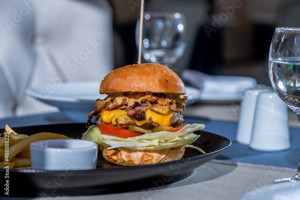 Obraz delicious big juicy hamburger on the table in the restaurant