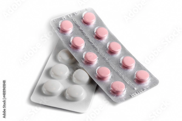 Fototapeta Close-up of a couple white pills or capsules on isolated white background.