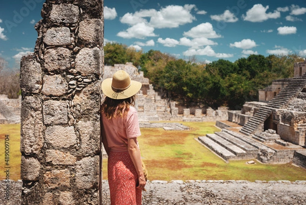 Fototapeta A young woman tourist stands against the backdrop of the Mayan ruins in the ancient city of Edzna.Edzna Campeche Mayan pyramids in Mexico. Travel concept.