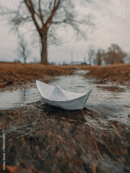 Fototapeta A paper boat floats on a spring stream