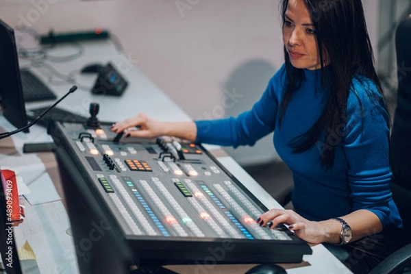 Fototapeta Middle aged woman using equipment in control room on a tv station