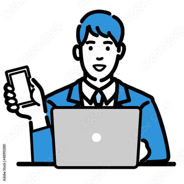Fototapeta ラップトップの前でスマートフォンを持っているスーツを着た若い男性
