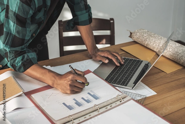 Fototapeta businessman working on desk office with using a computer to calculate the numbers, finance accounting concept. do math finance on wooden desk in office and business working background, tax.