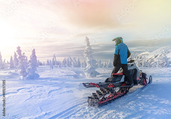 Obraz travel on a modern mountain snowmobile against the backdrop of beautiful mountain valleys after a snowfall. Extreme sport adventure, outdoor activity during winter holiday on ski mountain resort