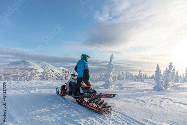 Obraz travel on a modern mountain snowmobile against the backdrop of beautiful mountain valleys after a snowfall. Extreme sport adventure, outdoor activity during winter holiday on ski mountain resort