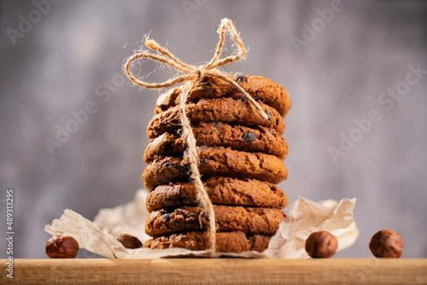 Fototapeta Homemade cookies with raisins, chocolate, nuts and milk on a wooden table and a art phone. Breakfast. Close up.