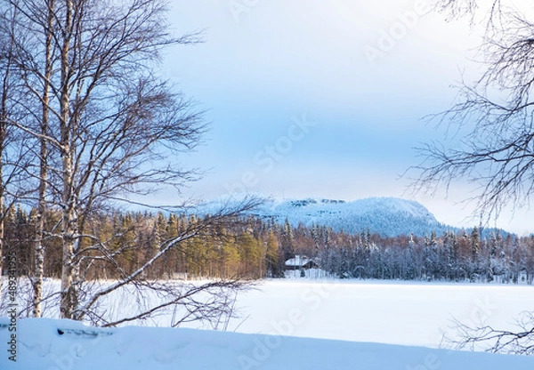 Fototapeta Snowy plain, frozen lake and winter landscape. Sunrise over the mountain.