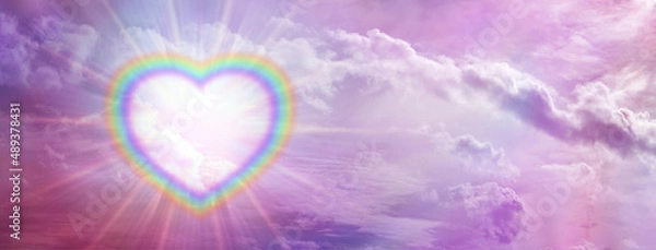 Fototapeta Rainbow love heart romantic  sky message banner - a large empty multicoloured border illuminated  heart creating a frame on left side of pink sky background with copy space for messages
