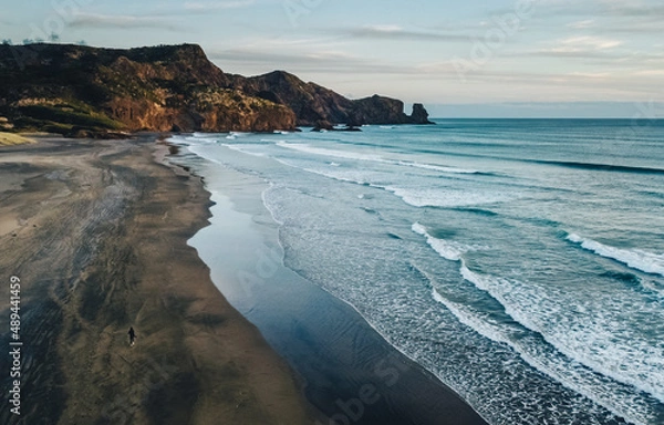 Obraz Aerial drone view of girl walking on the vast Bethells Beach