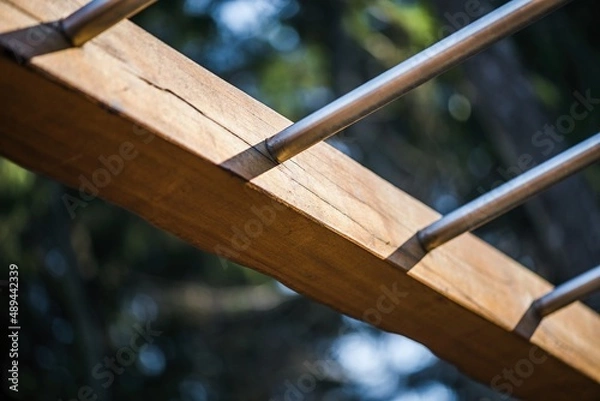 Fototapeta Ribs for strengthening the back and shoulders. City and forest gym, details of exercise aids made of stainless steel, rope and wood. Morning light for movement, exercise and energy.