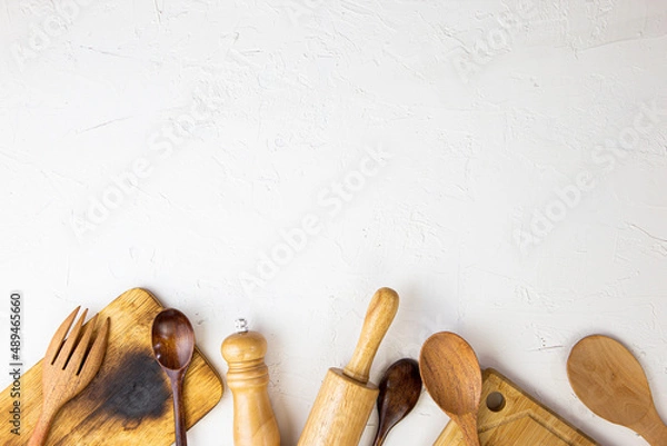 Fototapeta Wooden table, white kitchen set and cooking equipment / Top view with copy space for your.