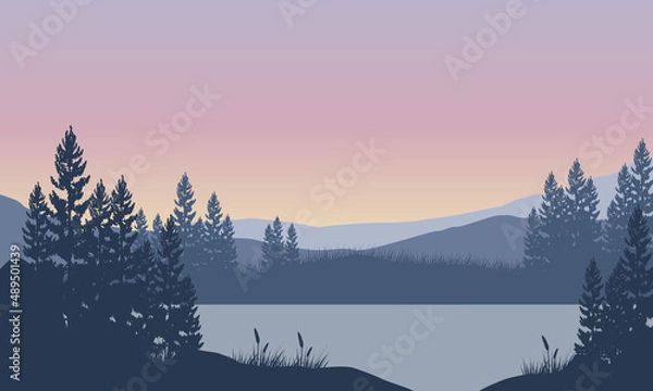 Obraz A magnificent view of the mountains with the silhouette of the pine trees at dusk from the riverbank