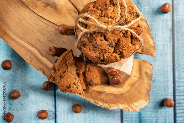 Fototapeta Homemade cookies with raisins, chocolate, nuts and milk on a wooden table and a art phone. Breakfast. Close up.