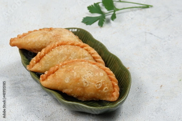 Fototapeta Curry puff or Pastel Goreng is Pastry Popular in Indonesia.
fried pastry with filling of sautéed vegetable , chicken and boiled egg. accompanied with  sauce or raw chilli pepper
