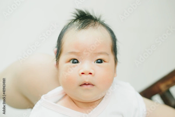 Obraz close up shot a cute newborn baby is looking in the camera.