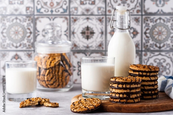 Fototapeta milk and chocolate cookies on a light background