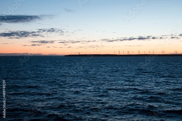 Fototapeta Lighthouse on a shore during sunrise.