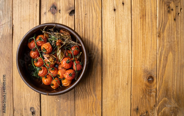 Obraz Stock photo plate of cherry tomatoes in a rustic bowl on a wooden background. 