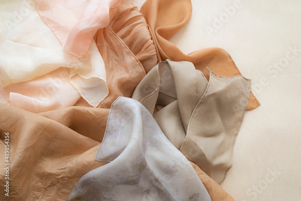 Fototapeta hand dyed clothes in warm natural tones hanging on a bright background - text space -
slow fashion concept 
