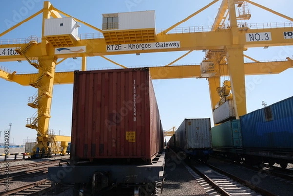 Fototapeta Khorgos / Kazakhstan - 10.06.2018 : Unloading containers at the logistics center. Machines and cranes drag metal boxes.