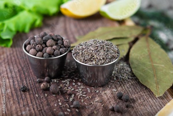 Fototapeta Pile of black pepper and caraway grain in vintage wooden background. Seasonings for cooking various dishes.