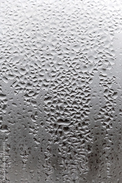 Fototapeta Vertical natural background, condensation on glass with drops flowing down, humidity and foggy blank. Outside , bad weather, rain