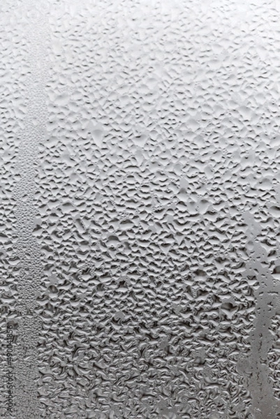 Fototapeta Water condensation on window glass background. Outside , bad weather, rain, humidity and foggy blank. Vertical natural background