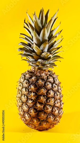 Obraz Beautiful fresh pineapple isolated on yellow background. Summer seasonal fruit design idea pattern concept. Copy space, close up