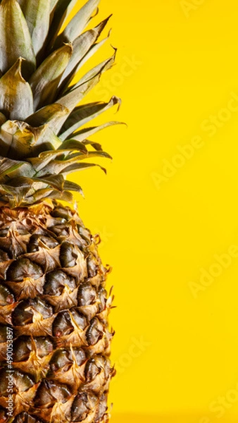 Obraz Beautiful fresh pineapple isolated on yellow background. Summer seasonal fruit design idea pattern concept. Copy space, close up