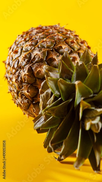 Obraz Beautiful fresh pineapple isolated on yellow background. Summer seasonal fruit design idea pattern concept. Copy space, close up