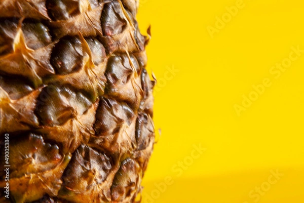 Obraz Beautiful fresh pineapple isolated on yellow background. Summer seasonal fruit design idea pattern concept. Copy space, close up