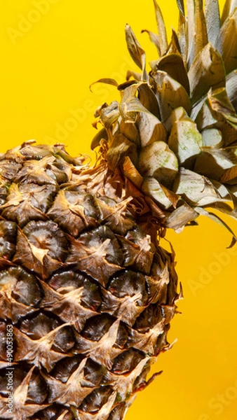 Obraz Beautiful fresh pineapple isolated on yellow background. Summer seasonal fruit design idea pattern concept. Copy space, close up