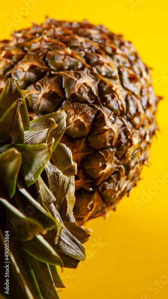 Obraz Beautiful fresh pineapple isolated on yellow background. Summer seasonal fruit design idea pattern concept. Copy space, close up