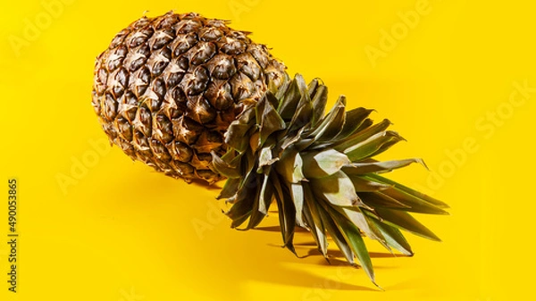 Obraz Beautiful fresh pineapple isolated on yellow background. Summer seasonal fruit design idea pattern concept. Copy space, close up