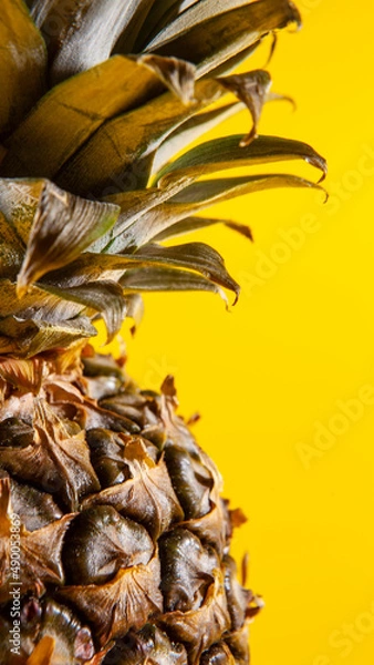Obraz Beautiful fresh pineapple isolated on yellow background. Summer seasonal fruit design idea pattern concept. Copy space, close up