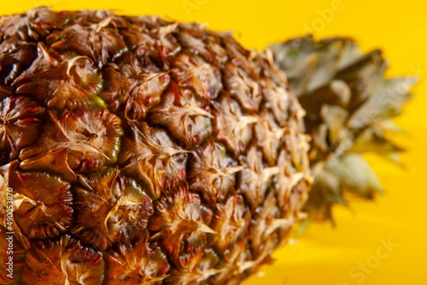 Obraz Beautiful fresh pineapple isolated on yellow background. Summer seasonal fruit design idea pattern concept. Copy space, close up