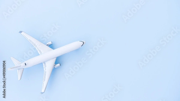 Fototapeta White airplane model on a blue background